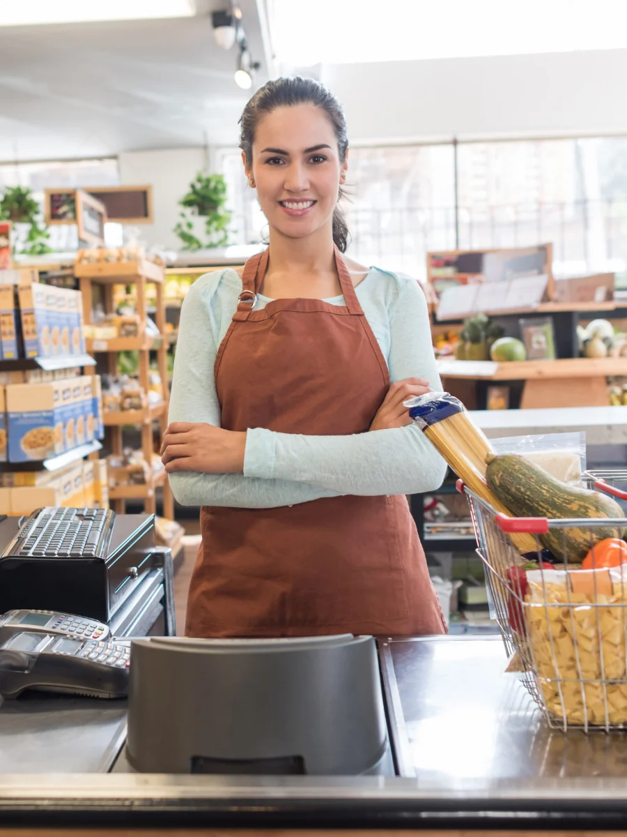 Marchand heureux les bras croisés devant sa caisse